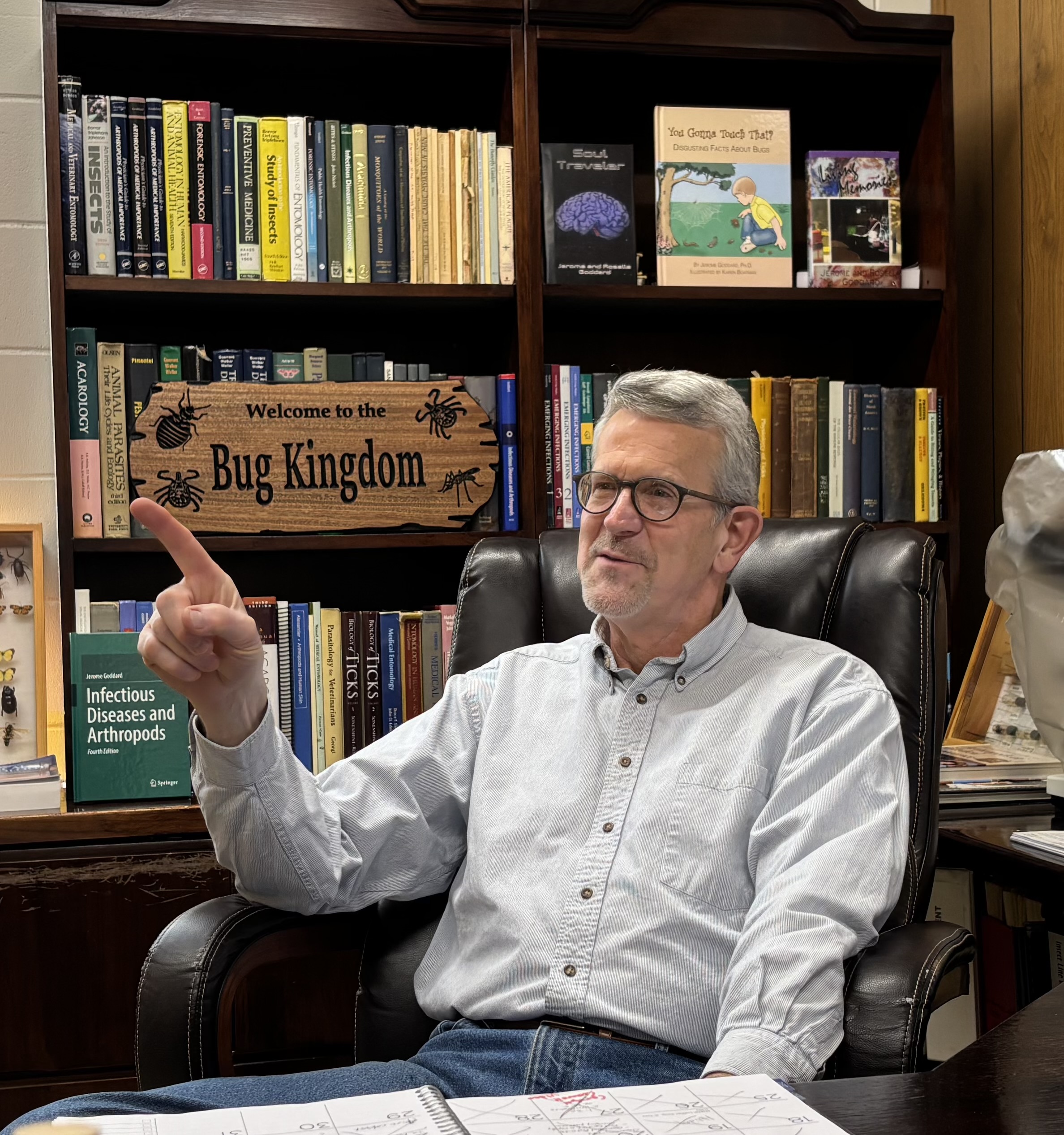 Jerome Goddard seated in his office with bookshelves behind him